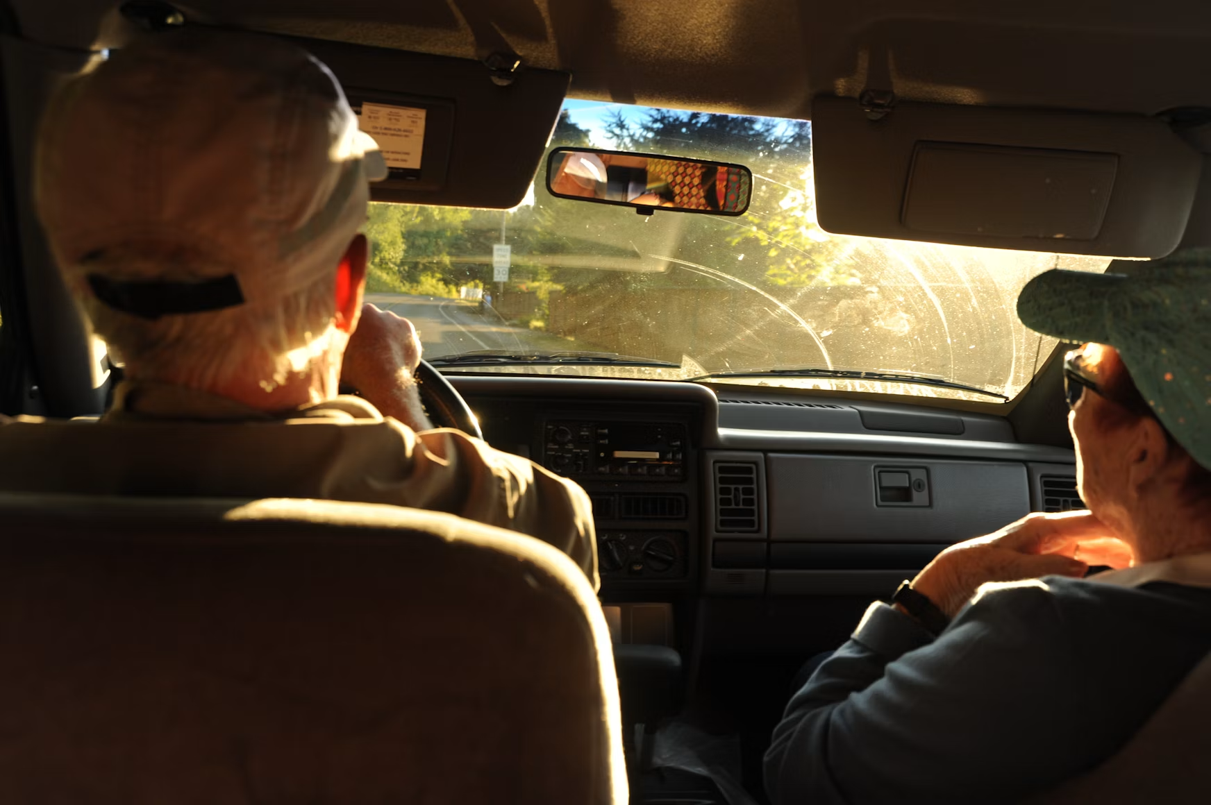 Golden-hour view from inside a car on a country road